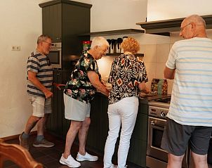 Gasten bereiden samen een maaltijd in de keuken van Vakantiehuisje in Bergeijk, Kempen.