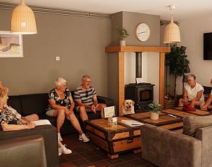 Comfortabele zithoek met open haard in Vakantiehuisje in Bergeijk, ideaal voor ontspanning.