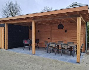 Overdekte buitenruimte met tafel in Huisje in Oirschot, vakantieverblijf in Kempen.