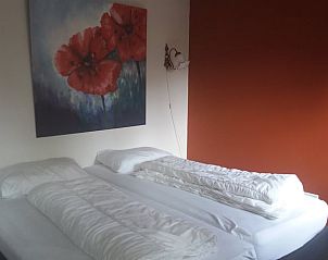 Gezellige slaapkamer met kunst in Huisje in Oirschot, vakantieaccommodatie in Kempen.