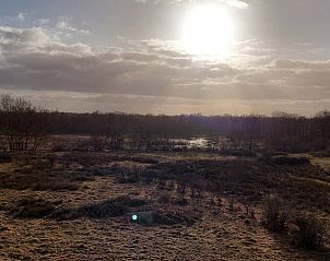 Uitgestrekt landschap met zonsondergang bij Huisje in Oirschot, vakantiewoning in Oirschot.
