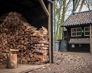 Huisje in Bladel, houtopslag en rustieke sfeer in de buitenruimte van vakantiewoning.