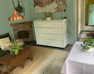 Gezellige binnenruimte van Vakantiehuis in Bladel, Kempen. Comfortabele zithoek met open haard en retro koelkast in Noord Brabant.