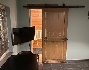 Gezellige binnenruimte van Vakantiehuis in Bladel, Kempen, Noord Brabant met rustieke houten deur en moderne voorzieningen.