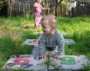 Kinderen spelen in de tuin van Huisje in Eersel, een vakantiehuis in Eersel, Kempen, Noord Brabant.