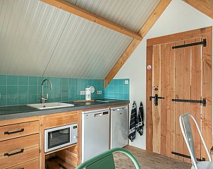 Moderne keuken in Huisje in Eersel, vakantiehuis in de Kempen, Noord Brabant, met houten afwerking en turquoise tegels.
