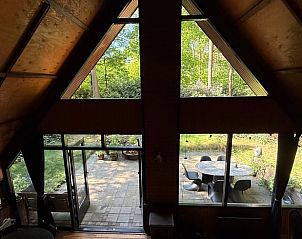 Binnenruimte van Huisje in Eersel, een vakantiehuis in Eersel, Kempen, Noord Brabant, met uitzicht op de groene tuin door grote ramen.