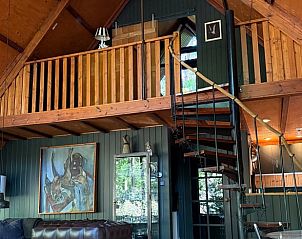 Gezellige woonkamer van Huisje in Eersel, een vakantiehuis in Eersel, Kempen, Noord Brabant, met houten interieur en een open trap.