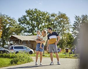 Gezin geniet van de natuur bij GlampingLodge in Eersel, Kempen, Noord Brabant, met uitzicht op de luxe safaritent en groene omgeving.