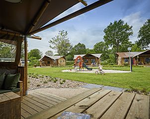 Gezellige veranda van LoungeLodge in Eersel, Kempen, met uitzicht op safaritenten en speeltuin, ideaal voor een ontspannen vakantie in Noord Brabant.
