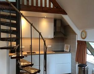 Moderne keuken in Vakantiehuisje in Eersel, Noord Brabant, met houten trap en gezellig interieur voor een comfortabel verblijf.