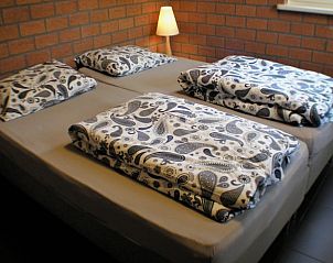 Slaapzaal in Vakantiehuisje in Luyksgestel met meerdere bedden, ideaal voor groepen of families.