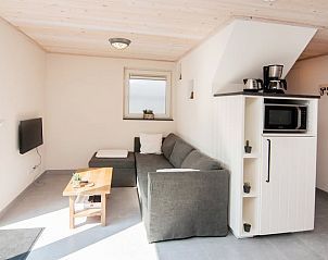 Gemtliches Wohnzimmer des Ferienhauses in Hapert, Kempen, Nordbrabant, mit bequemem Sofa und moderner Ausstattung.