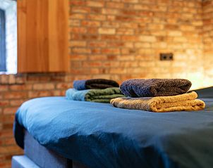 Verse handdoeken op bed in De Hoeve I, vakantiehuis in Hulsel, Kempen, Noord Brabant.