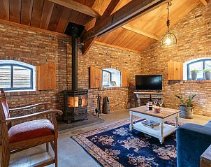 Woonkamer met kachel en tv in De Hoeve I, vakantiehuis in Hulsel, Kempen, Noord Brabant.