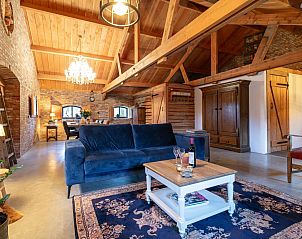 Ruime woonkamer met houten balken in De Hoeve I, vakantieverblijf in Hulsel, Kempen, Noord Brabant.