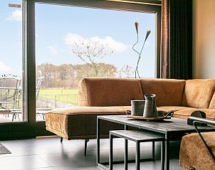 Gezellige zithoek in De Hoeve II vakantiehuis, Hulsel, met uitzicht op de groene omgeving van de Kempen, Noord Brabant.