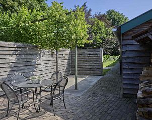 Buitenterras van De Hoeve III, vakantiehuis in Hulsel, met zitgelegenheid en groene omgeving in de Kempen, Noord Brabant.