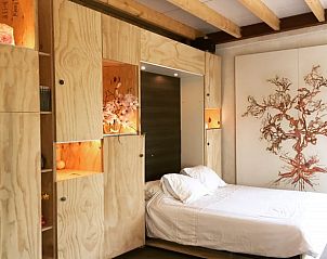 Comfortabele slaapkamer in Vakantiehuisje in Liempde met artistieke muurdecoratie.