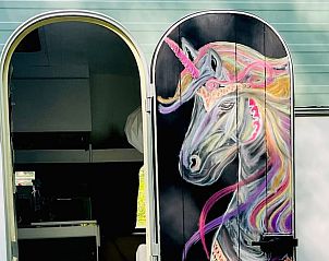 Kunstzinnige details op de deur van de caravan bij Vakantiehuis in Liempde, een creatief verblijf in Hart van Brabant, Noord Brabant.