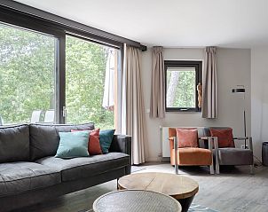 Ontspan in de stijlvolle woonkamer van Sommerhus Helsinki, een vakantiehuis in Chaam, Hart van Brabant, omgeven door groene natuur.