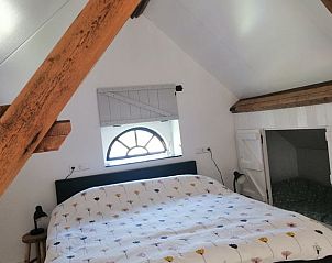 Knusse slaapkamer met houten balken in Huisje in Kaatsheuvel, Noord Brabant.