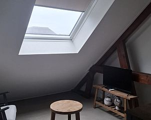 Lichte woonkamer in Vakantiehuisje in Hank, Noord Brabant, met groot raam voor natuurlijk licht in het Hart van Brabant.