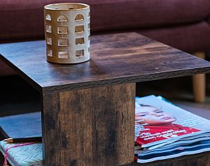 Gezellige binnenruimte van Vakantiehuisje in Berlicum, Hart van Brabant, met stijlvolle houten salontafel en tijdschriften.