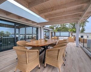 Ruim terras van Vakantiewoning Vrijstaande woning in Maashees met houten eettafel en prachtig uitzicht in Noord-Brabant.