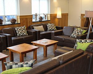 Comfortabele loungehoek in de Heidehof, Schaijk, met lederen banken en houten tafels in Noord Brabant.