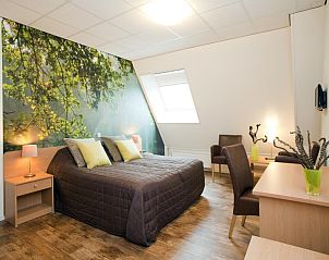 Sfeervolle slaapkamer in de Heidehof vakantiehuis met bosbehang en comfortabel bed in Schaijk.