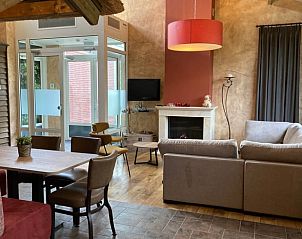 Stijlvolle zithoek met open haard in Vakantiehuis in Schaijk, Noord Brabant, ideaal voor ontspanning.