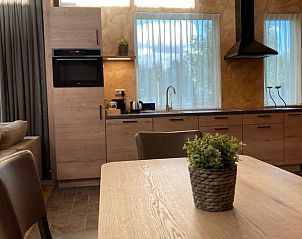 Moderne keuken en eetruimte in Vakantiehuis in Schaijk, Noord Brabant met uitzicht op de tuin.