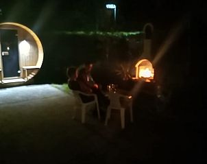 Vakantiehuis in Schaijk, Noordoost Brabant met sfeervolle avondverlichting en een gezellige open haard.