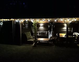 Vakantiehuis in Schaijk, Noord Brabant met verlichte buitenruimte en comfortabele zitplaatsen voor avondontspanning.