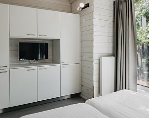 Geniet van de rust op het terras van vakantiehuis Patio 4 in Schaijk, Noord Brabant, omringd door groene natuur en moderne architectuur.