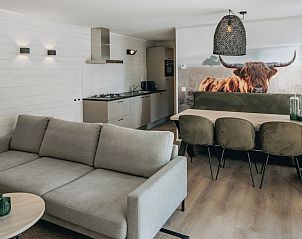 Gezellige woonkamer van Forest Villa 6 in Schaijk, Noordoost Brabant, met moderne keuken en sfeervolle eethoek in vakantiehuis.