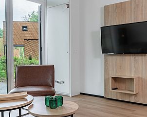 Moderne woonkamer in Forest Cabin 4, een vakantiehuis in Schaijk, Noordoost Brabant, met uitzicht op de groene omgeving.