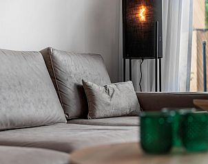 Gezellige zithoek in Forest Cabin 4, een vakantiehuis in Schaijk, Noordoost Brabant, met comfortabele bank en sfeervolle verlichting.