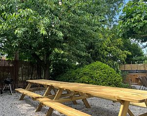 Ruime picknicktafel onder bomen bij Vakantiehuis in Overloon, perfect voor buitenmaaltijden in Noord Brabant.