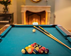 Pooltafel met open haard op de achtergrond in Vakantiehuis in Oeffelt, Noordoost Brabant, voor een gezellige sfeer.