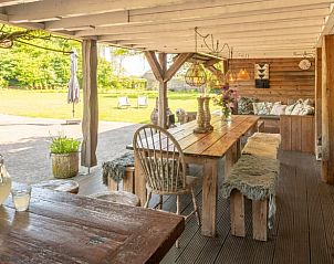 Overdekt terras met houten meubels in Vakantiehuis in Oeffelt, Noordoost Brabant, ideaal voor buiten dineren.