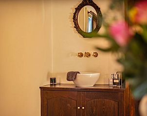 Stijlvolle wastafel en spiegel in Vakantiehuis in Oeffelt, Noordoost Brabant, met een klassieke uitstraling.