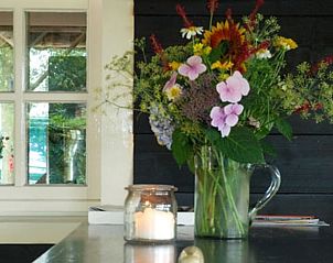 Bloemen in een vaas binnen Vakantiehuis in Oeffelt, Noord Brabant, met sfeervolle inrichting.