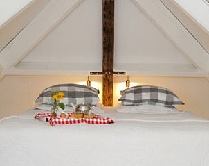 Knusse slaapkamer met houten balken in Vakantiehuis in Oeffelt, Noord Brabant.