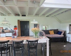 Ruime woonkamer met bloemen in Vakantiehuis in Oeffelt, Noordoost Brabant.