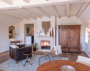 Comfortabele woonkamer met open haard in Huisje in Oeffelt, vakantieaccommodatie in Oeffelt.