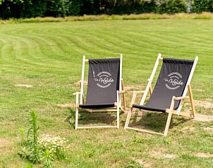 Zonnige tuin met ligstoelen bij Huisje in Oeffelt, vakantiehuis in Oeffelt.