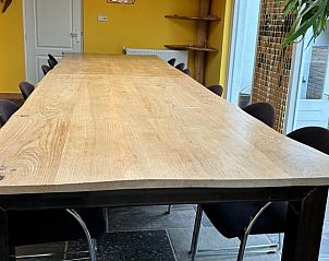 Ruime eetkamer met houten tafel in Huisje in Gemert, vakantieverblijf in Noordoost Brabant.