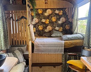 Knusse binnenruimte van het vakantiehuis Huisje in Sint Anthonis, Noord Brabant, met sfeervol bed en decor.